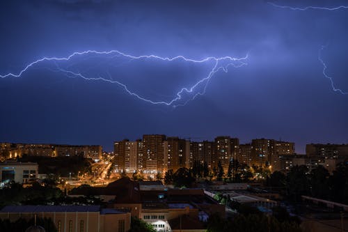 Lightning over a city at night with buildings in the background