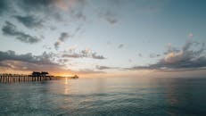 码头后面平静海面上的日落景色令人惊叹