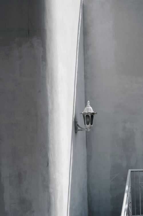 Free A minimalist view of a staircase with a traditional outdoor lantern casting shadows. Stock Photo