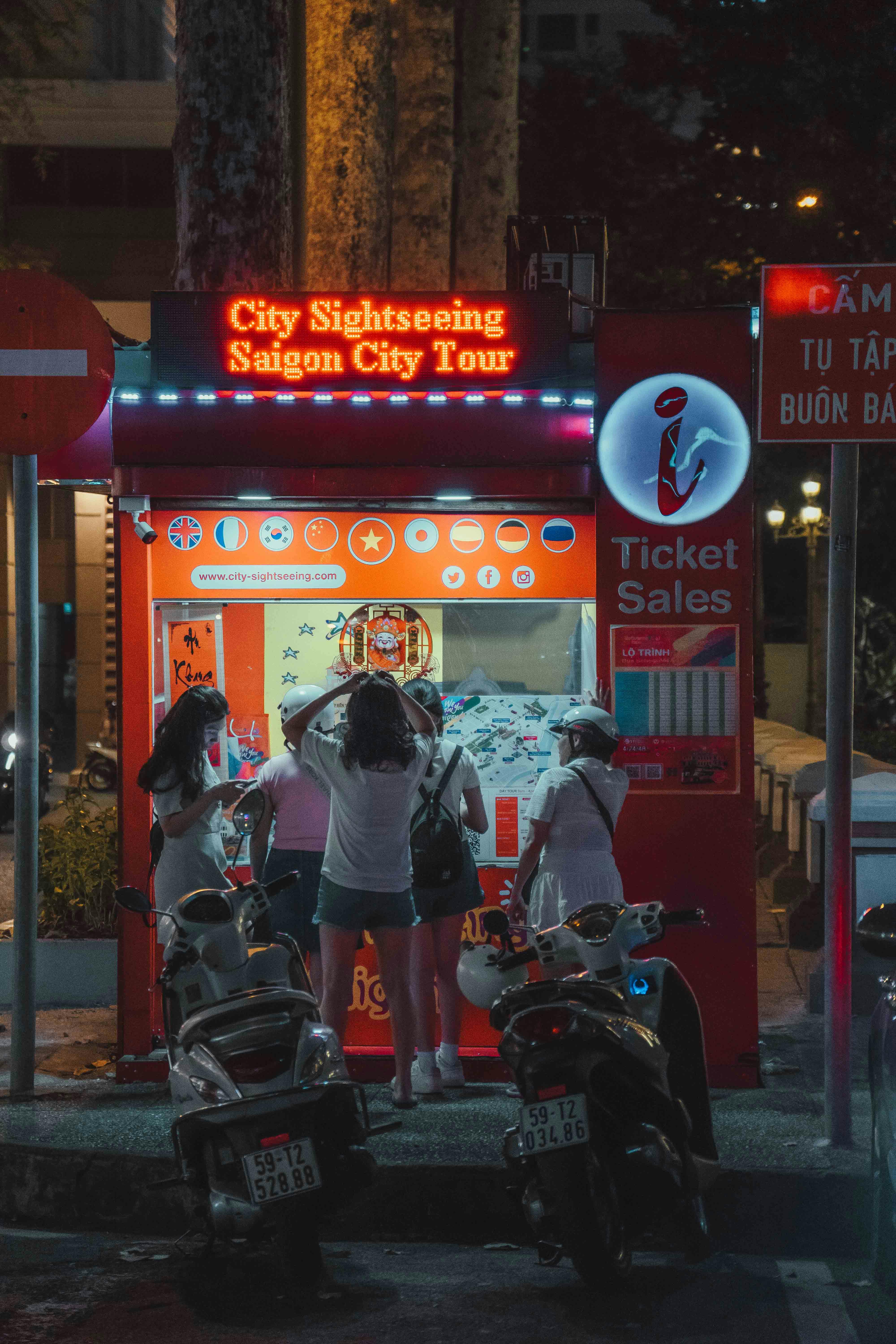 Vibrant street scene showing motorbikes and tourists in Ho Chi Minh City at night.