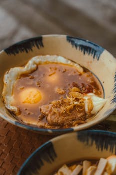 Close-up of a flavorful bowl of Vietnamese pho with eggs and tender meat in soup.