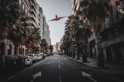A dramatic street view in Vigo, Spain with an airplane flying overhead.