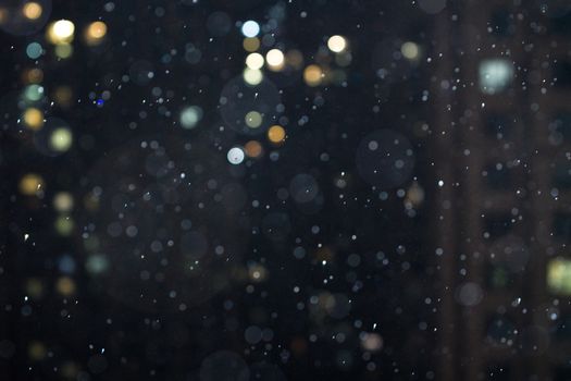Captivating night scene with raindrops and city lights in an artistic bokeh effect.
