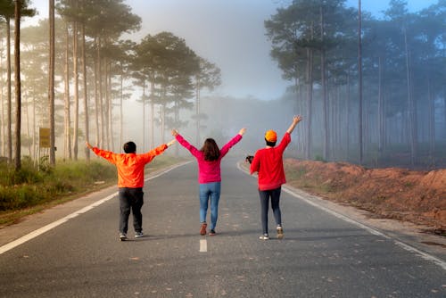 Free Back view photo of three people walking on road Stock Photo