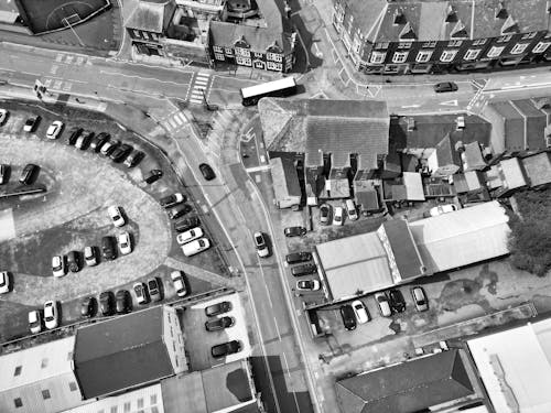 An aerial view of a city street with cars parked