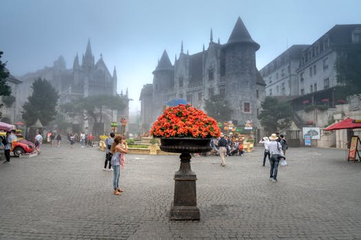 游客们在一个装饰着鲜艳花朵的雾蒙蒙城堡广场上探索，这里非常适合旅行和建筑主题