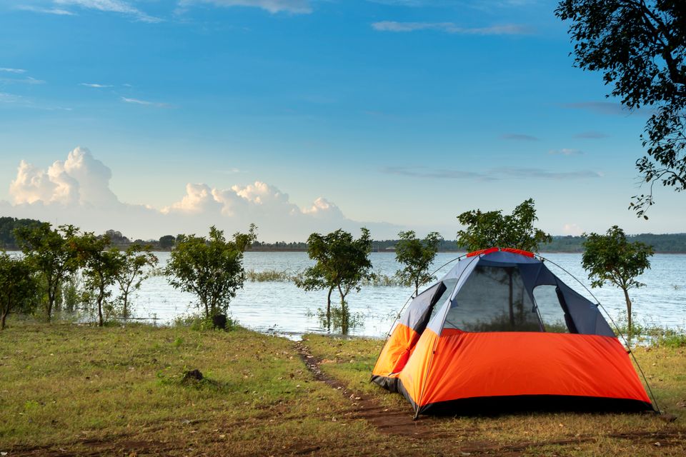 Tent and sleeping setup on a beach at dusk