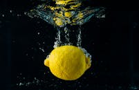 充满活力的柠檬在水下飞溅的动态中被捕捉，突显了其新鲜感
