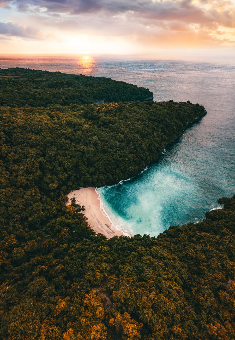 Aerial view of a secluded tropical island surrounded by blue ocean water near Bali Indonesia