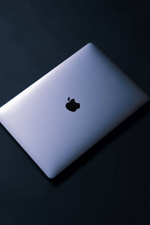 An apple macbook air is shown on a dark surface