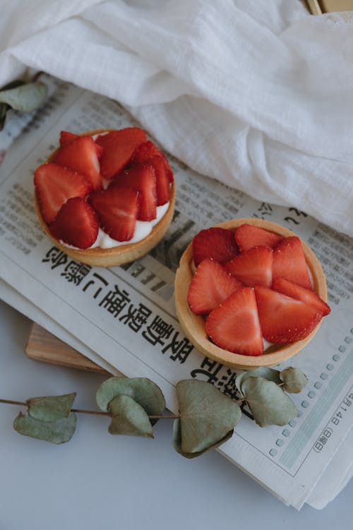 A strawberry tart on top of a newspaper