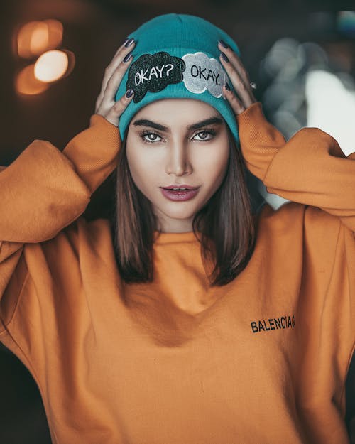 Photo of a Woman in Yellow Sweater Holding Her Head