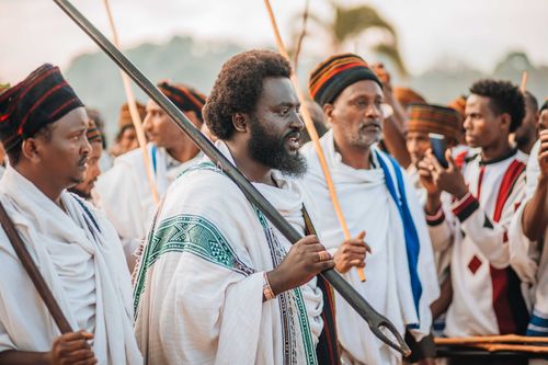 Free Men in traditional African clothing participating in a cultural ceremony outdoors. Stock Photo