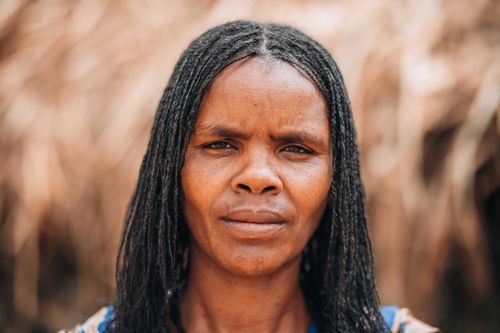 Free Close-up portrait of a woman with braided hair, expressing thoughtful emotion outdoors. Stock Photo