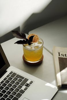 A glass of lemonade with herbs and ice beside a laptop, set in Istanbul.