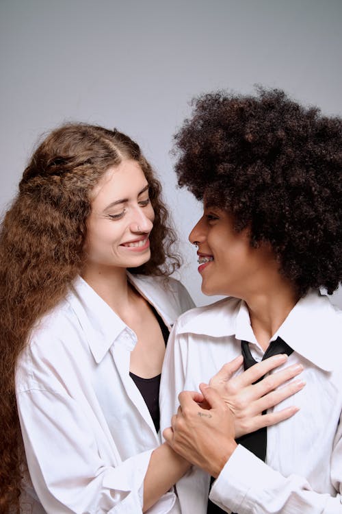 Two Young Affectionate Women against a White Background