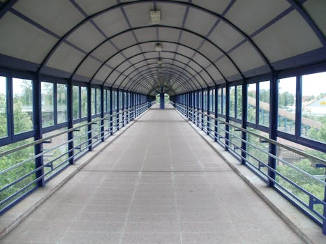 一座有盖的宽人行天桥，在现代城市环境中融入了几何设计元素