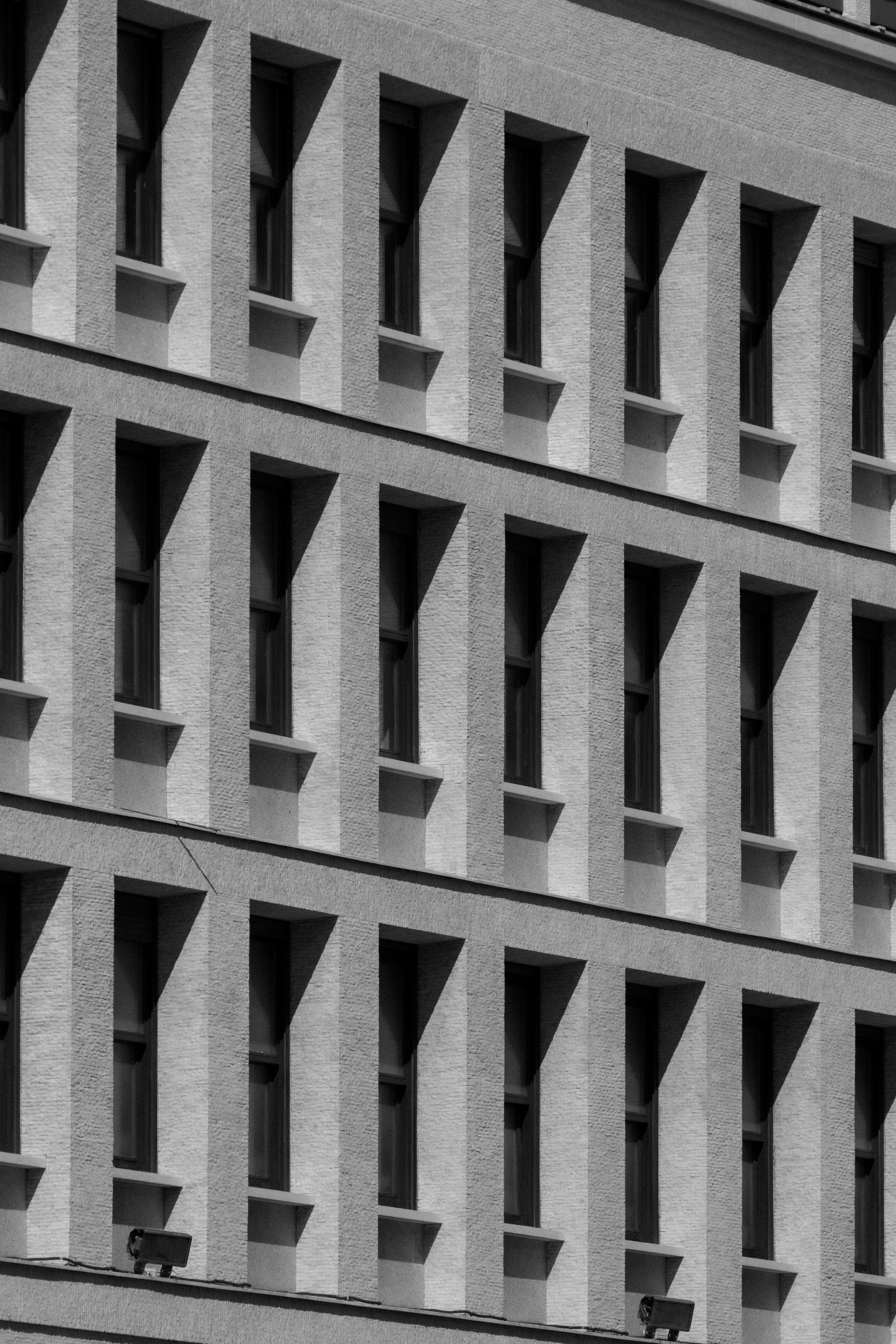 Monochrome view of a modern building facade with repeating windows.