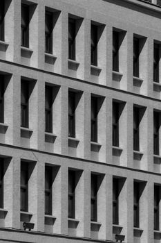 Monochrome view of a modern building facade with repeating windows.
