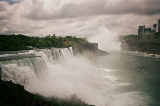 Breathtaking view of Niagara Falls surrounded by mist on an overcast day.