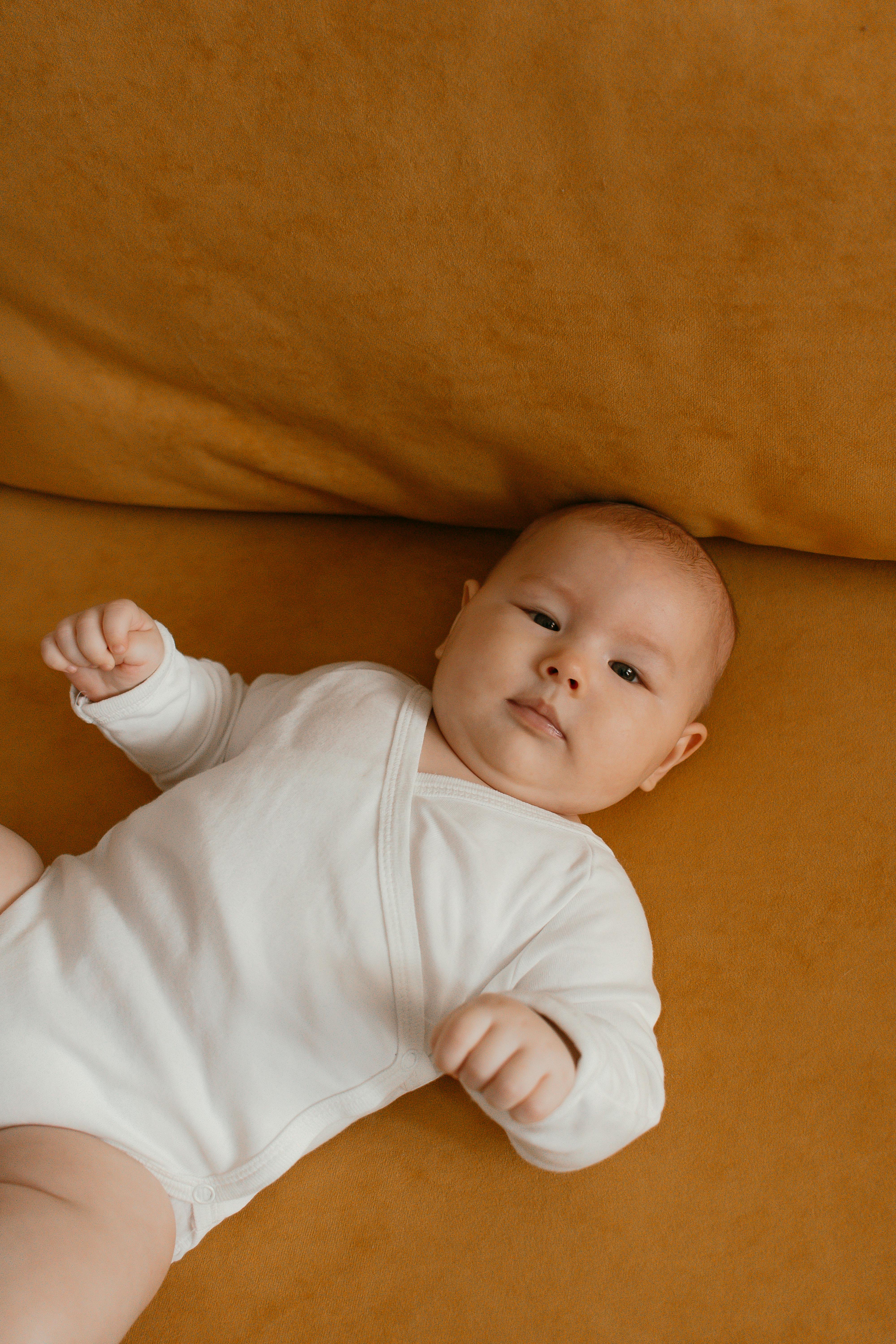 baby lying down in overalls