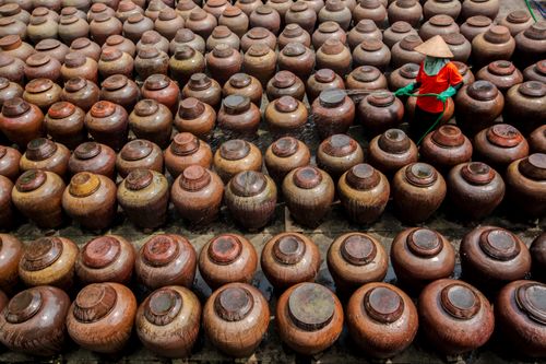 Free Aerial view of a Vietnamese worker tending to clay jars in Hưng Yên, Vietnam. Stock Photo