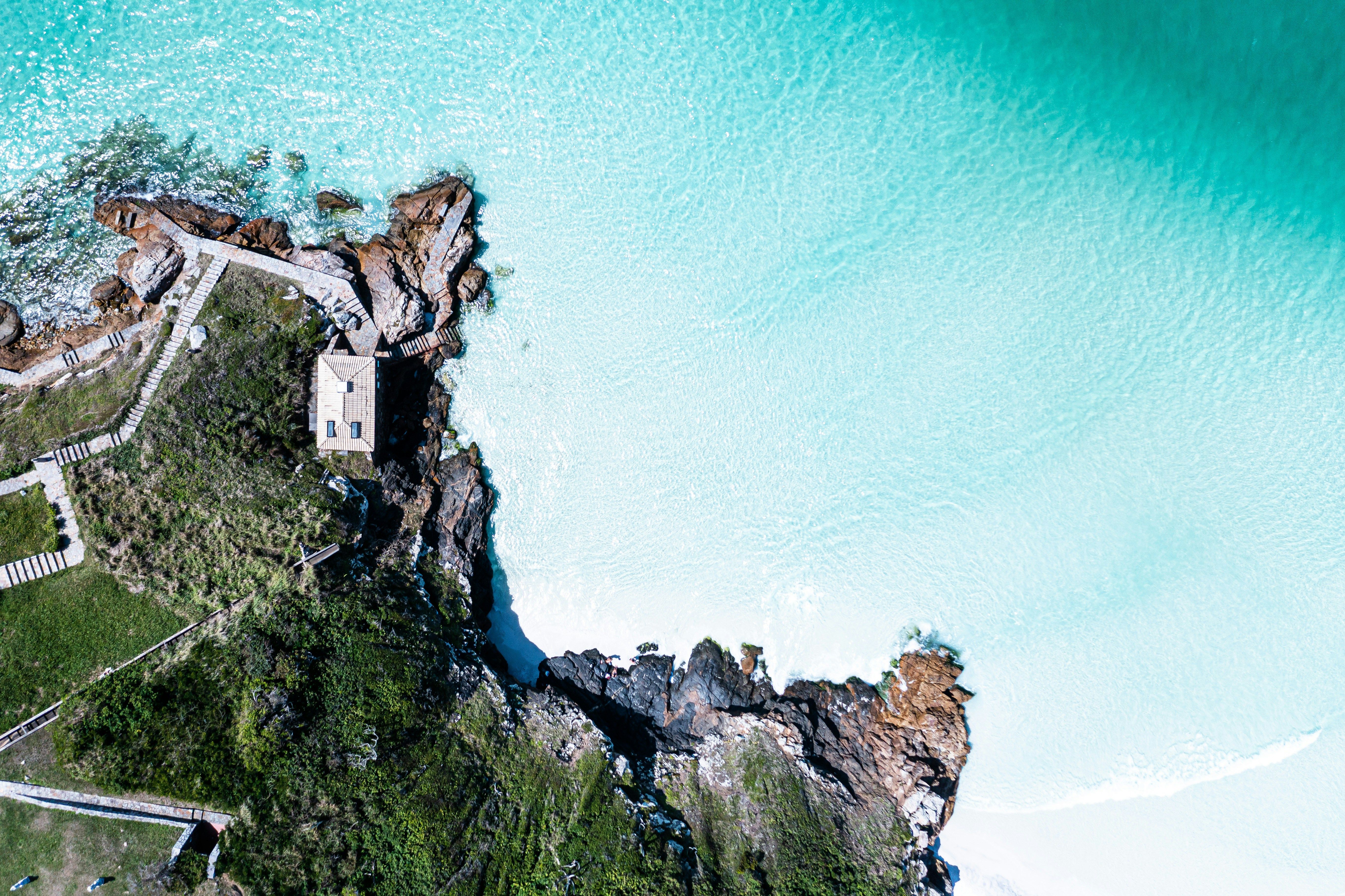 Aerial view of the ocean and a lighthouse · Free Stock Photo