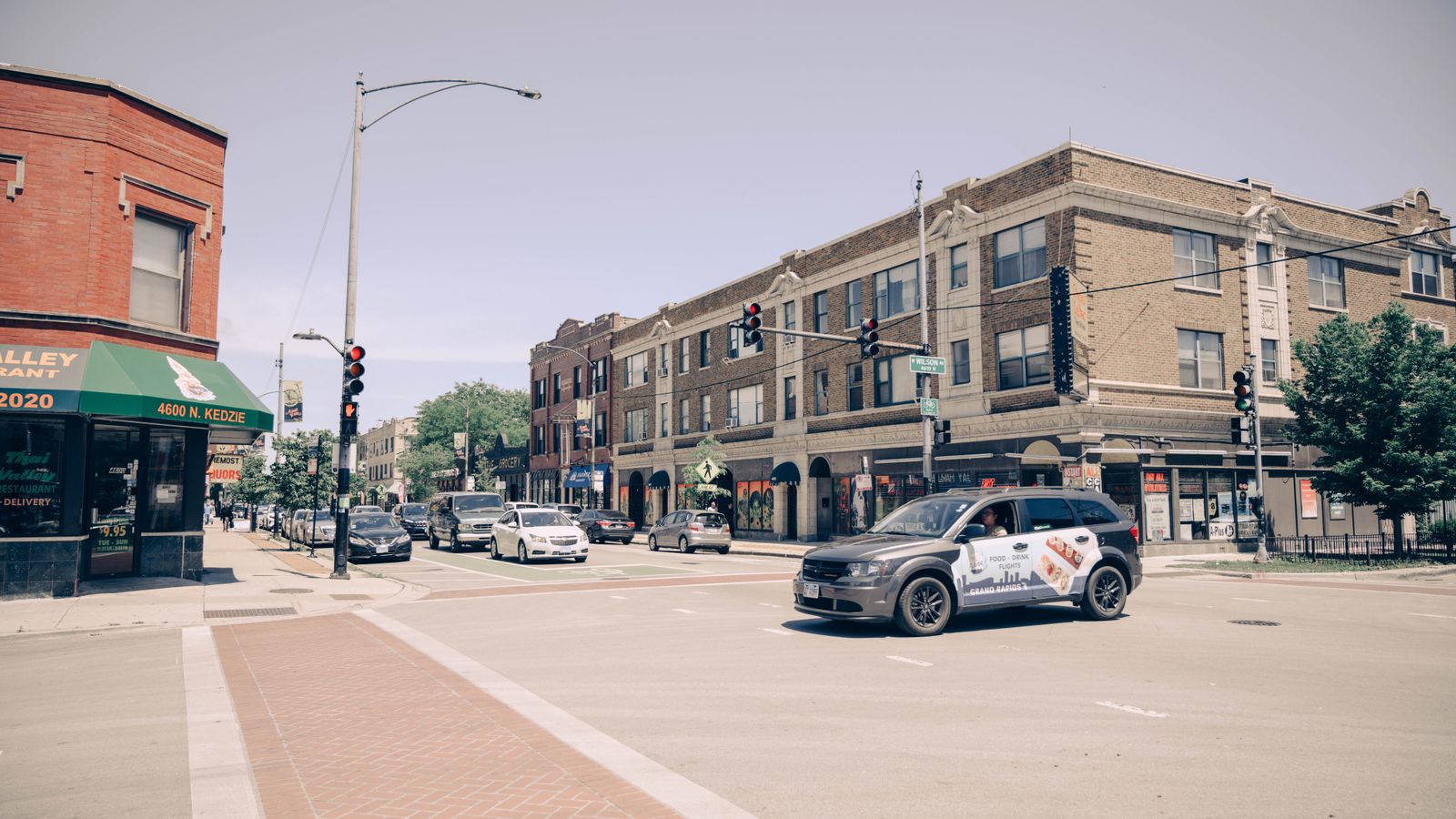 Urban street scene of a busy intersection in Chicago with cars and brick buildings.