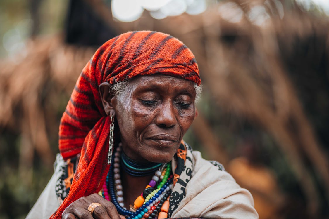 An african woman with a red headband and a red scarf