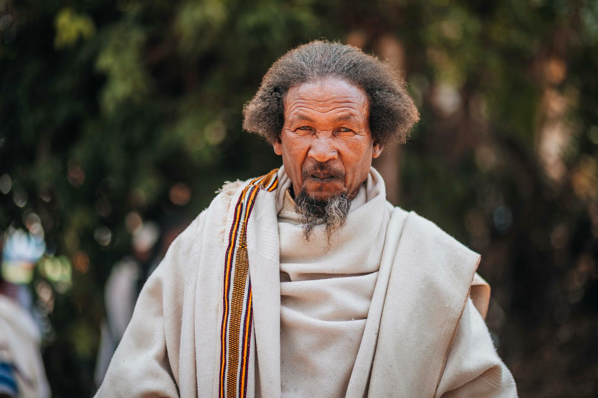 Portrait of a senior Ethiopian man wearing traditional robes, reflecting cultural heritage outdoors.