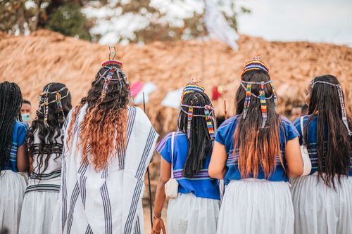 Free A group of women wearing traditional clothing participating in a cultural ceremony outdoors. Stock Photo