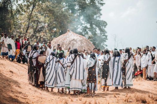 A vibrant traditional ceremony with people in cultural attire outdoors.