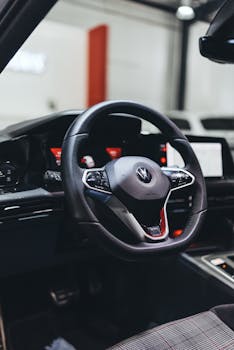 Close-up of a sleek car steering wheel and dashboard in a modern vehicle interior.
