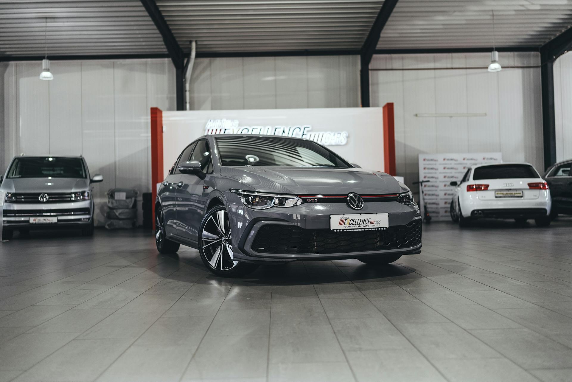 A sleek Volkswagen car in a modern indoor dealership setting featuring several vehicles.