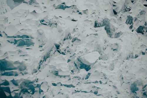 Free Close-up aerial shot of a snowy glacier showing intricate ice formations and textures. Stock Photo
