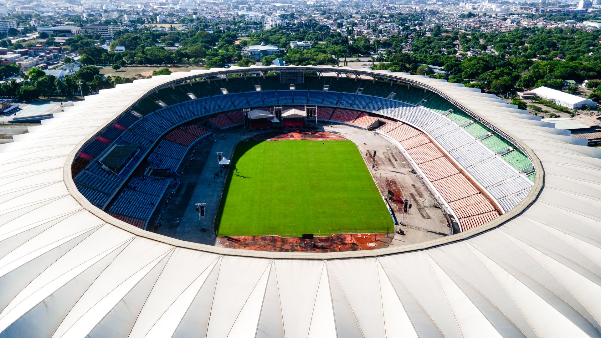 Aerial view of Benjamin Mkapa Stadium in Dar es Salaam, showing the vibrant green field and surrounding cityscape.