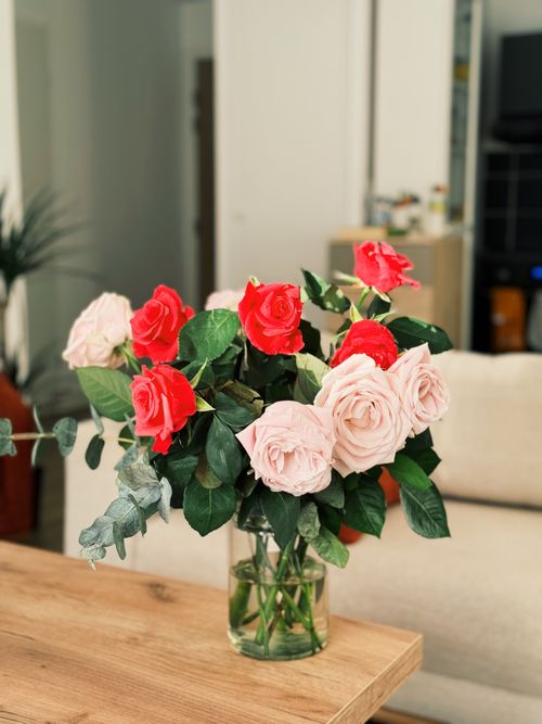 Free Beautiful red and pink rose bouquet in a glass vase, adding elegance to indoor decor. Stock Photo