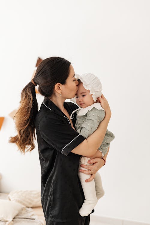 Fotos de stock gratuitas de bebé niña, besando, camisa negra