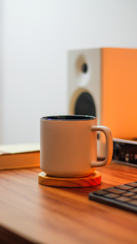 Close-up of a coffee mug on a desk with a warm ambiance, perfect for productivity.