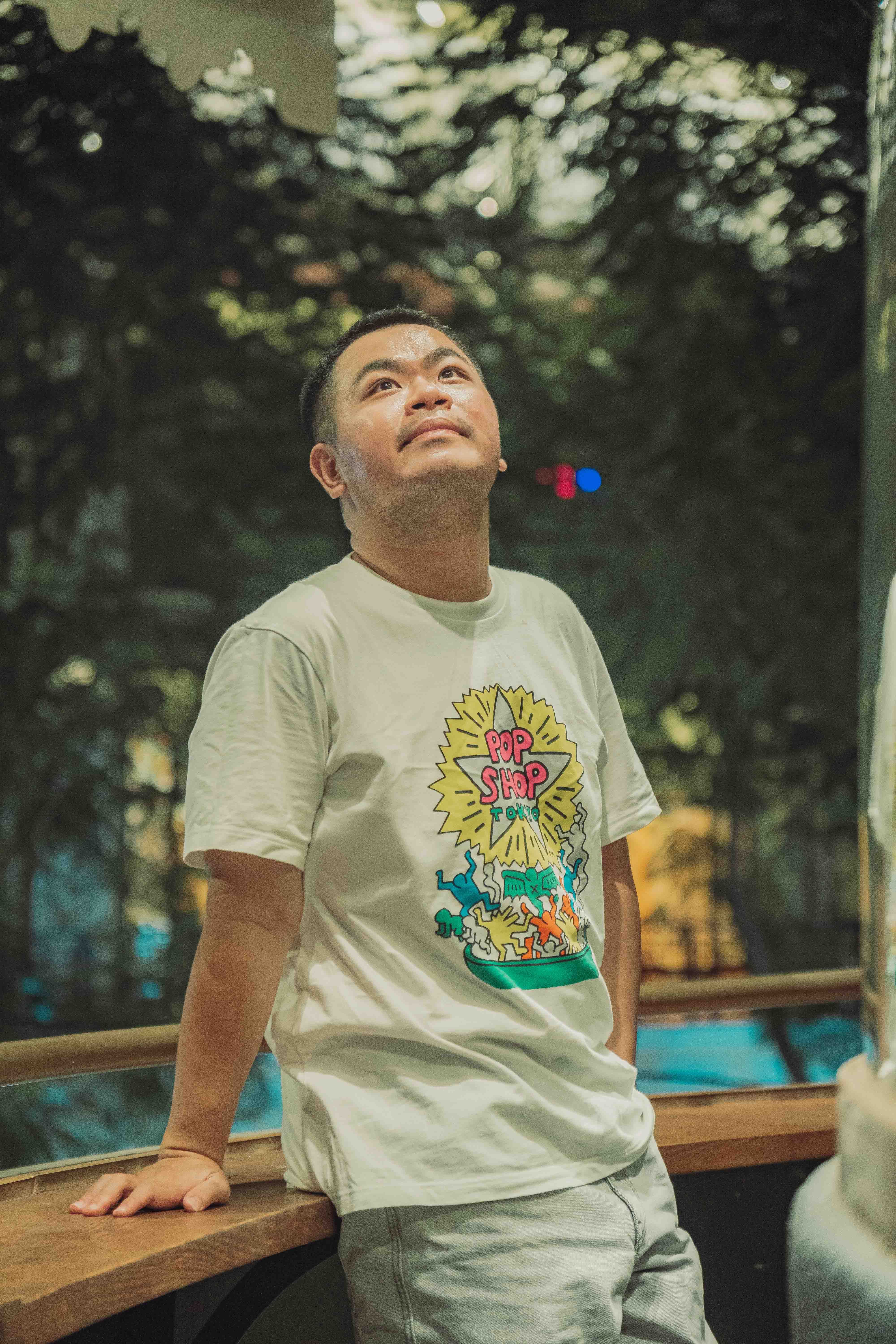 A serene moment of a man gazing upwards in a park in Ho Chi Minh City, Vietnam.