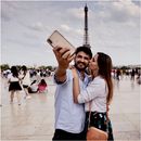 一对夫妇在巴黎埃菲尔铁塔前拥抱拍照