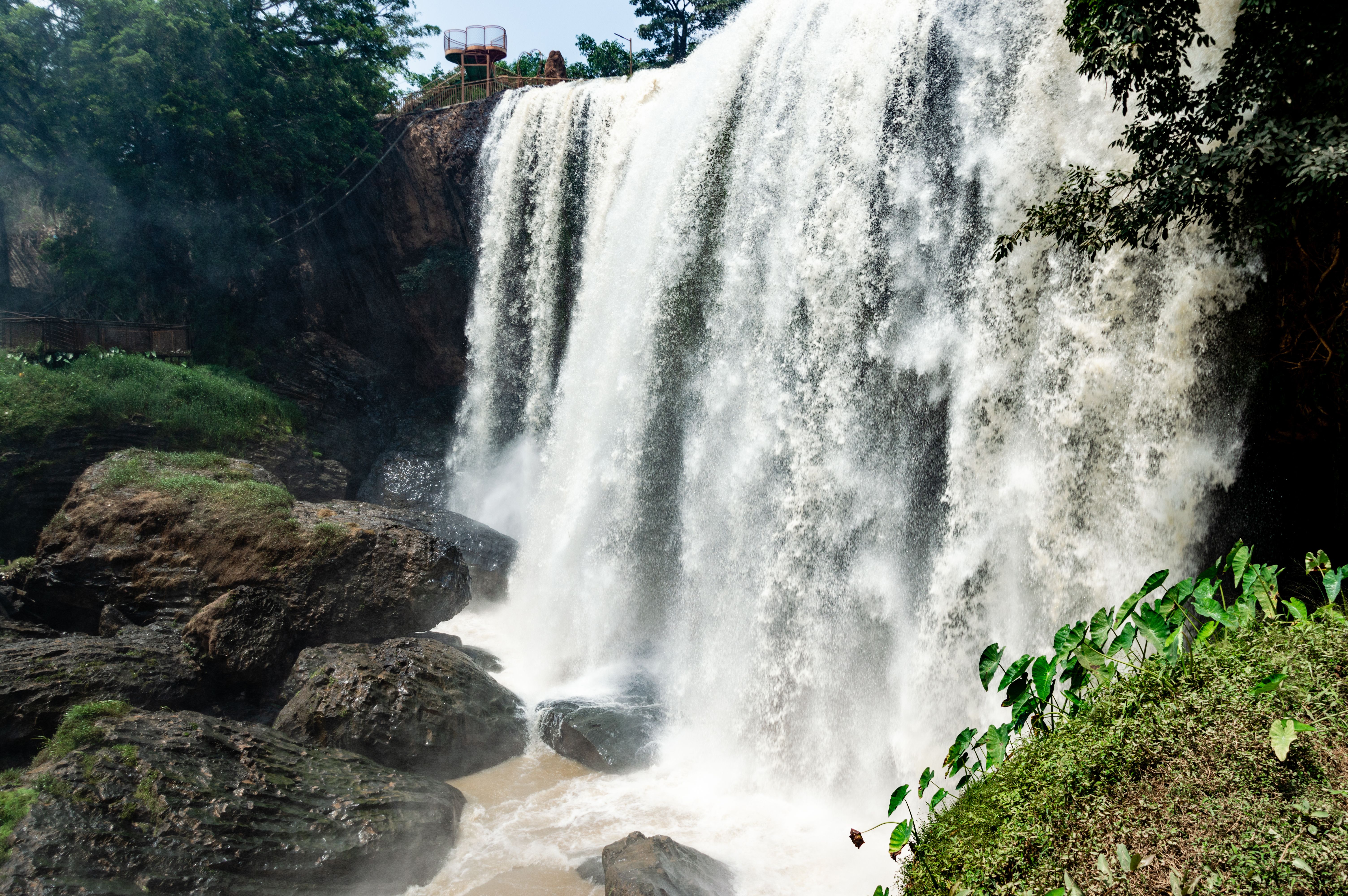 A breathtaking waterfall flowing over rocky cliffs surrounded by lush greenery in a tranquil park.