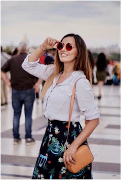 在巴黎，一位时尚的女人戴着红色太阳镜微笑