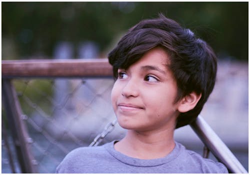 Fotografía De Enfoque Superficial De Un Niño Mirando Hacia Los Lados