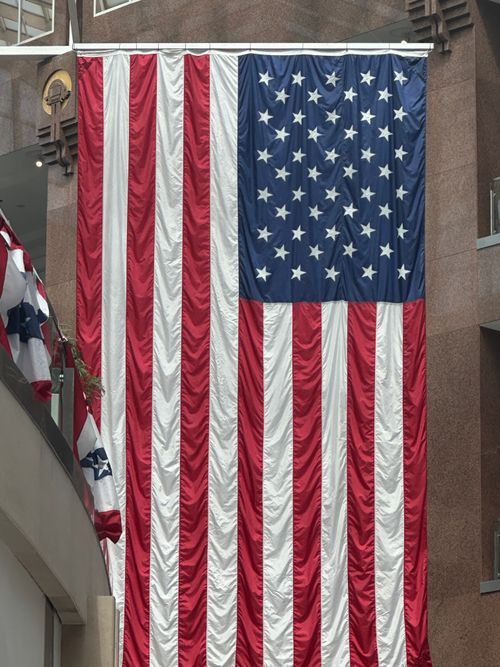 Free A massive American flag hangs indoors in Arlington, VA, USA, symbolizing patriotism and national pride. Stock Photo