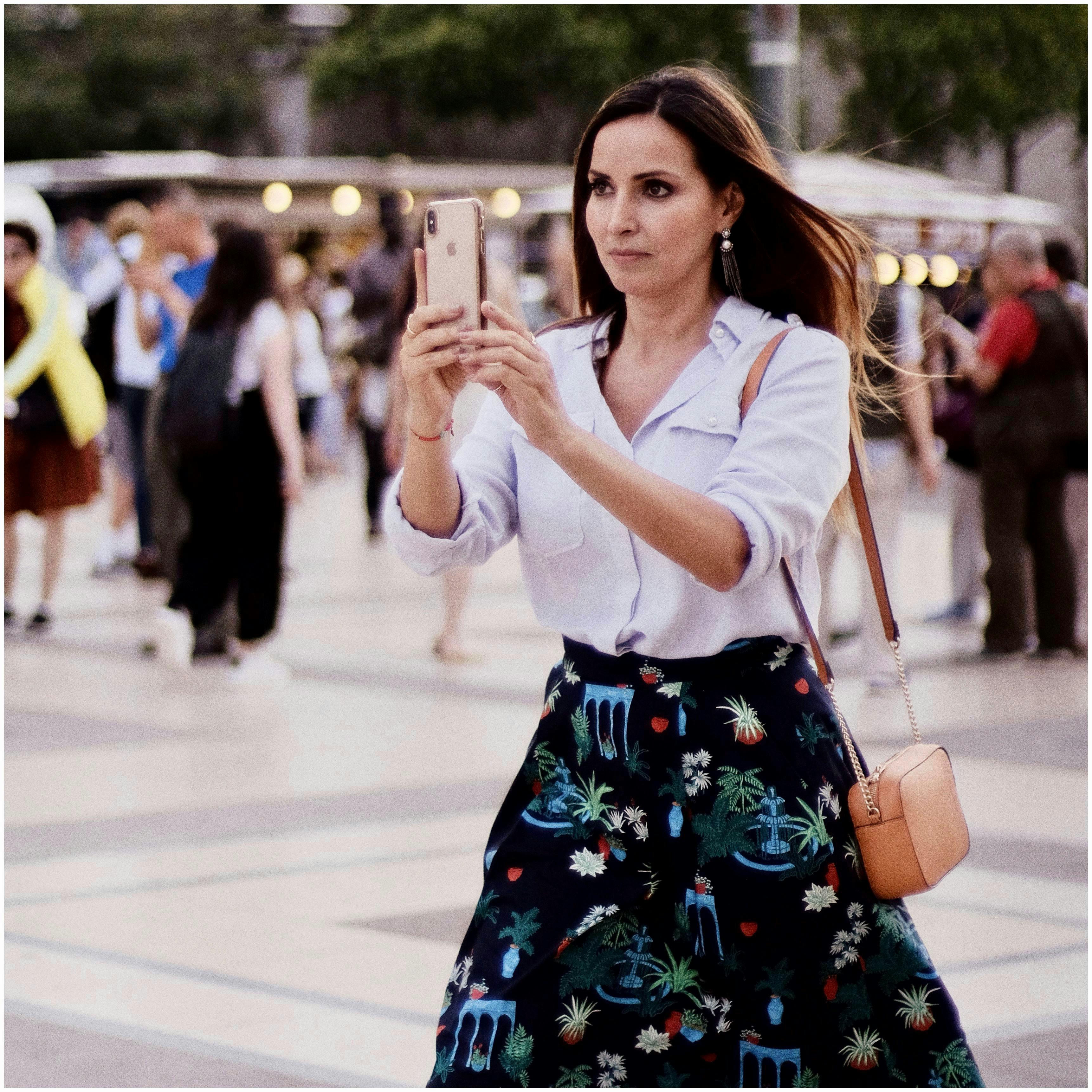 photo of a woman taking a photo using her cellphone