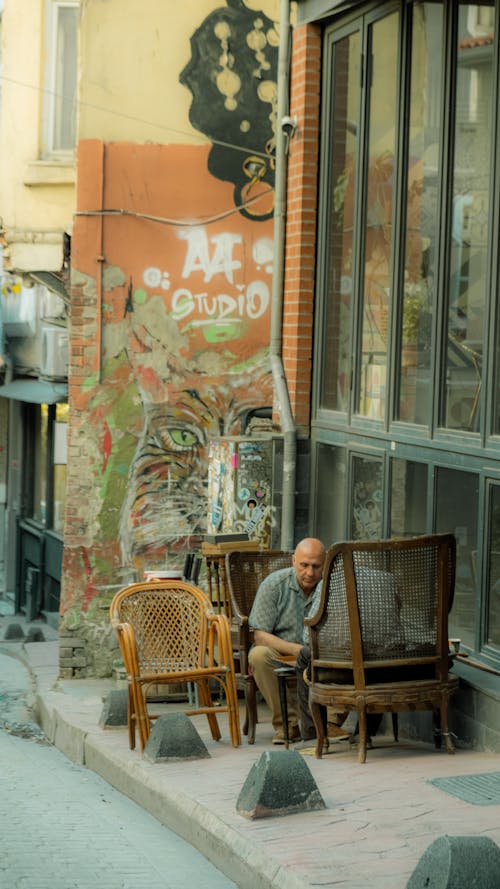 A man sitting in a chair on a sidewalk