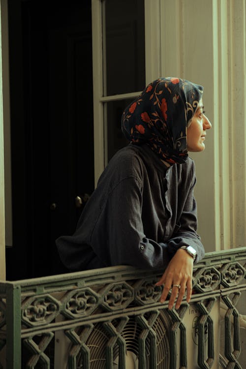 A woman in a hijab looking out of a window