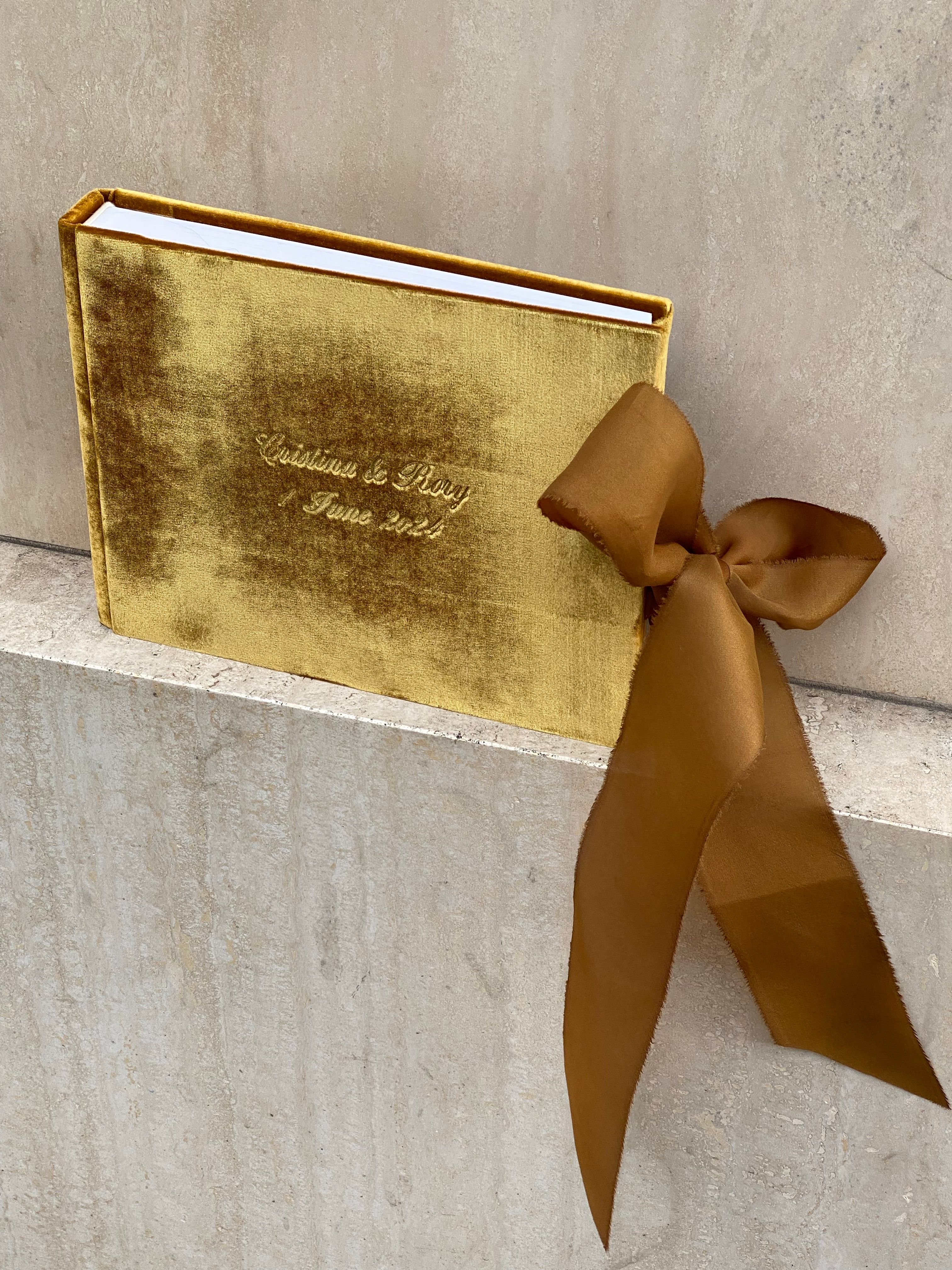 A gold book with a ribbon tied to it · Free Stock Photo
