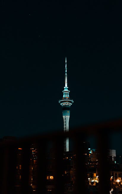 Stunning night view of illuminated Sky Tower in Auckland, New Zealand skyline.